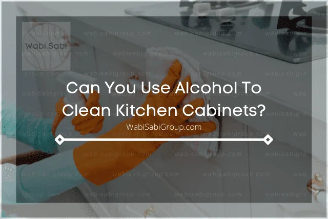 A photo of a person's hand cleaning the kitchen cabinet with alcohol