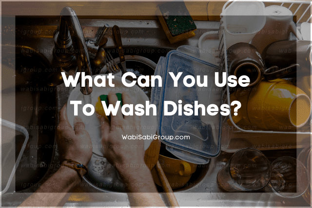 A photo of a person's hand washing the dishes on a sink full of dirty utensils, plates and containers